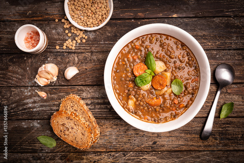 Canvas-taulu Traditional Spanish dish of lentil stew with chorizo and potatoes on a wooden background
