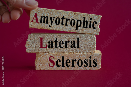 Obraz na płótnie Amyotrophic Lateral Sclerosis symbol on brick blocks. Brick blocks with words Amyotrophic Lateral Sclerosis. Beautiful red background. Doctor hand. Medical concept. w salonie