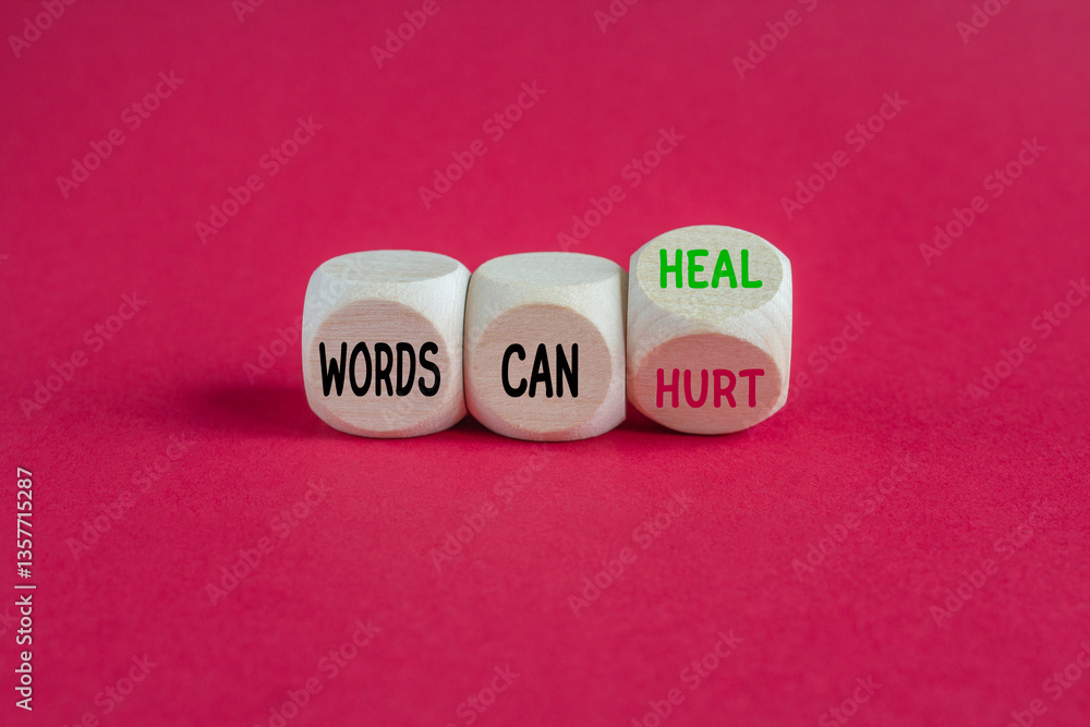 Turned a wooden cube and changes the expression Words can hurt to Words can heal. Beautiful red background. Business concept.
