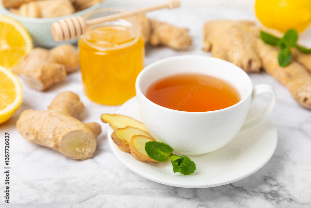 Cup of hot ginger tea with slices of ginger root on wooden background. Warming drink. Alternative medicine. Tea with honey, lemon, ginger and mint. Space for text. Copy space Cup of hot ginger tea with slices of ginger root on wooden background. Warming drink. Alternative medicine. Tea with honey, lemon, ginger and mint. Space for text. Copy space