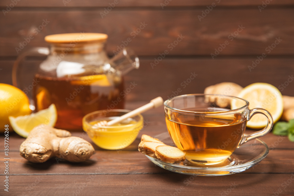 Cup of hot ginger tea with slices of ginger root on wooden background. Warming drink. Alternative medicine. Tea with honey, lemon, ginger and mint. Space for text. Copy space Cup of hot ginger tea with slices of ginger root on wooden background. Warming drink. Alternative medicine. Tea with honey, lemon, ginger and mint. Space for text. Copy space