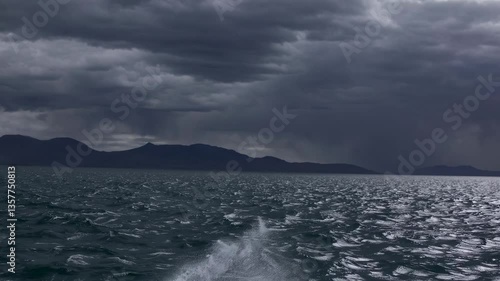 Dramatic seascape video with a low-angle view of choppy waters under a stormy sky, capturing the moody essence of nature's power. Live desktop wallpaper.
