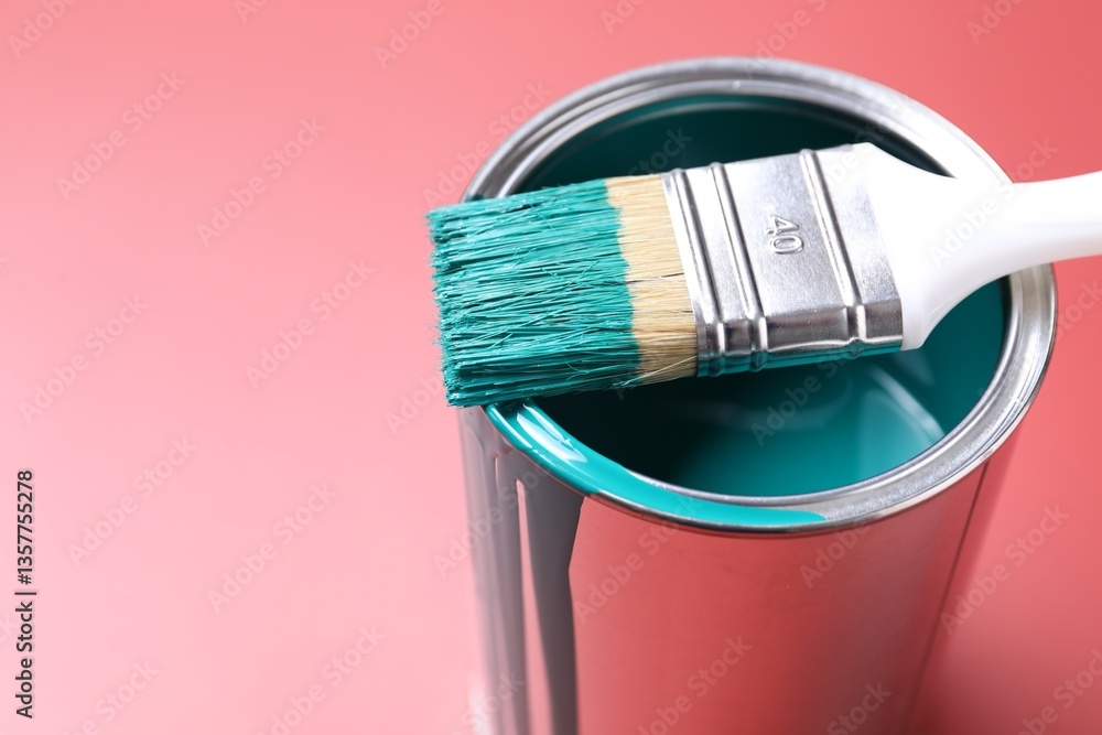 Can of teal paint and brush on color background, closeup. Space for text