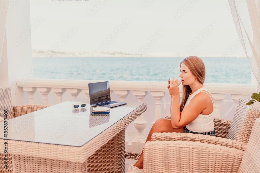Obraz premium Woman coffee cafe macbook. Woman sitting at a coffee shop with mobile phone drinking coffee and looking away. Caucasian female relaxing at a cafe.