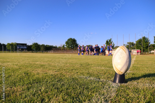Close up of an rugby football on the field, players in the background