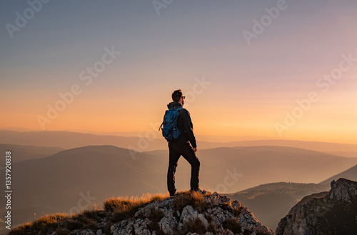 A man who hikers enjoys a break look at the top of the mountain at sunset adventure travel.