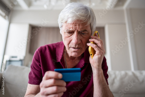 Quadro su tela Trusting serious feared pensioner giving away card number to fraudsters over phone