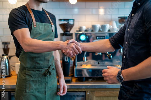 Barista shakes hands with customer in a modern coffee shop during a morning visit