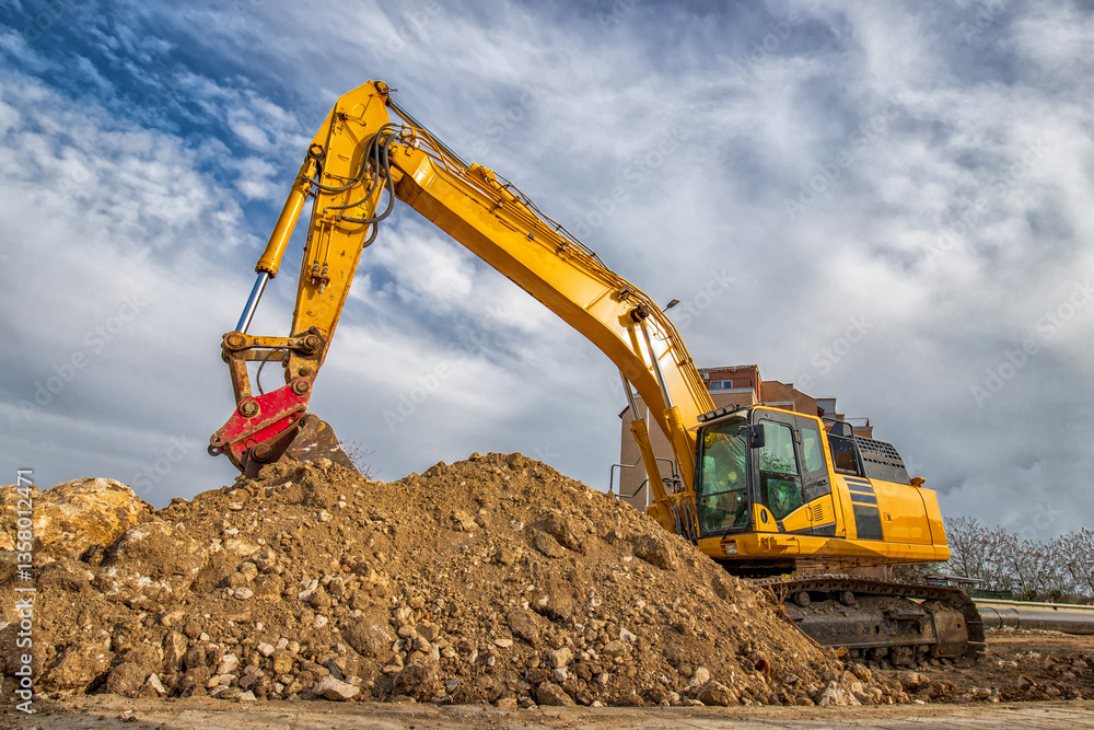 A stopping yellow excavator, at a construction site