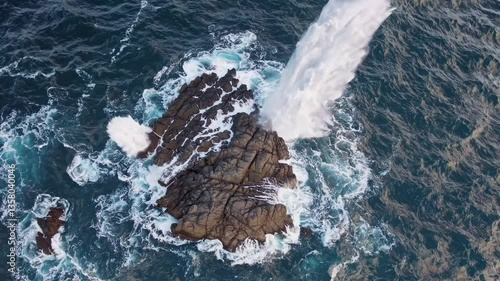Aerial video captures waves crashing over rugged rocks, showcasing the dynamic power of the ocean from a top-down perspective.