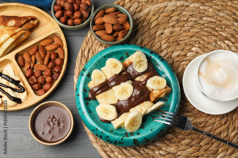 Delicious crepes served with chocolate paste, nuts and coffee on grey wooden table, flat lay Delicious crepes served with chocolate paste, nuts and coffee on grey wooden table, flat lay