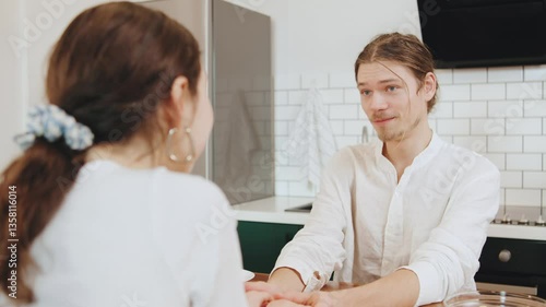Wallpaper Mural A couple shares a tender and playful moment in a modern kitchen, leaning in closely as they engage in lighthearted activity, creating a warm atmosphere of togetherness. Torontodigital.ca