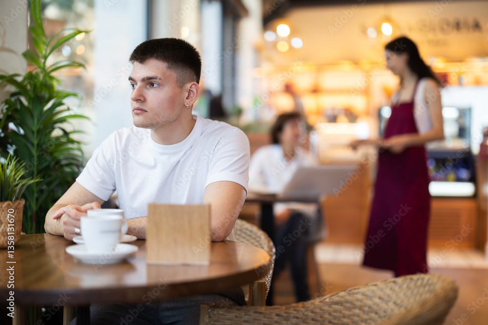 European guy enjoys drinking delicious aromatic coffee brewed from natural Arabica beans in a coffee shop European guy enjoys drinking delicious aromatic coffee brewed from natural Arabica beans in a coffee shop