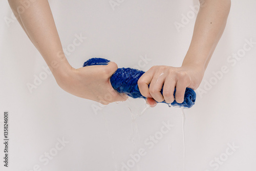 Close-up of Hands Wringing Out a Wet Sponge