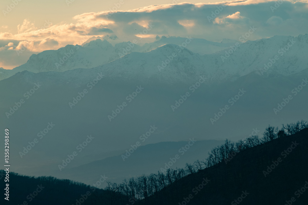 Naklejka premium Central massif of Gredos at sunset. Lines of mountains on the horizon with orange and cyan blue colors
