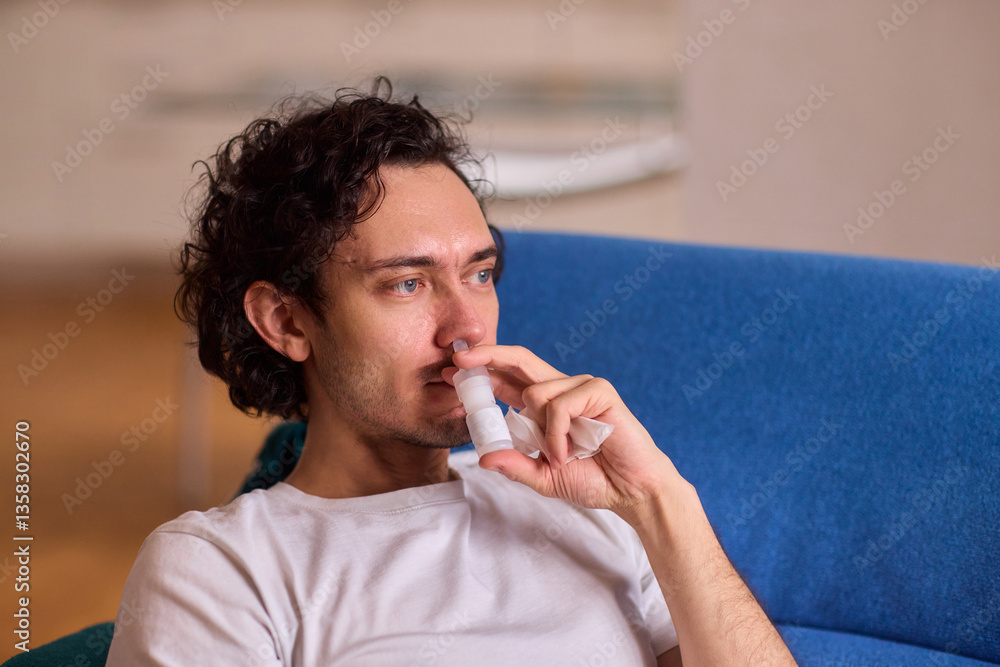 A Man Using an Inhaler While He is Relaxing Comfortably at Home in a Cozy Environment A Man Using an Inhaler While He is Relaxing Comfortably at Home in a Cozy Environment