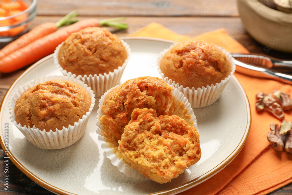 Tasty carrot muffins, fresh vegetables and walnuts on wooden table, closeup Tasty carrot muffins, fresh vegetables and walnuts on wooden table, closeup