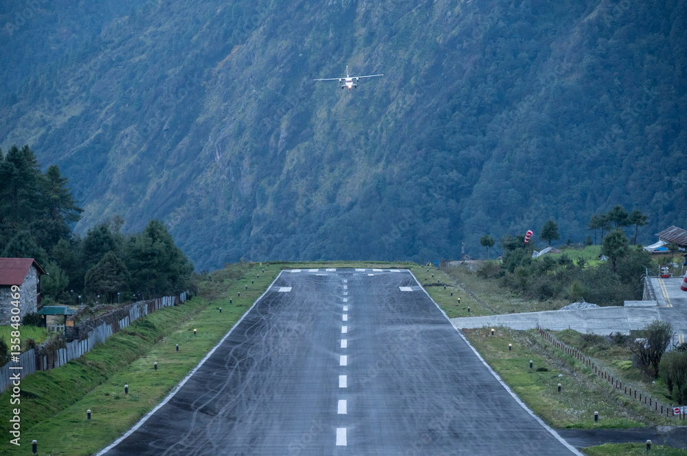 Obraz premium An aircraft before landing on the runway in Lukla airport the most dangerous airport in the world in Nepal. The runway rests on a hillside in the town of Lukla, Nepal.