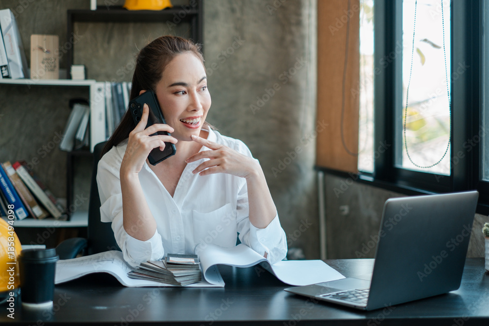 Businesswoman multitasking in a modern office, talking on the phone, using a laptop, and reviewing documents. Bright and productive workspace. Businesswoman multitasking in a modern office, talking on the phone, using a laptop, and reviewing documents. Bright and productive workspace.
