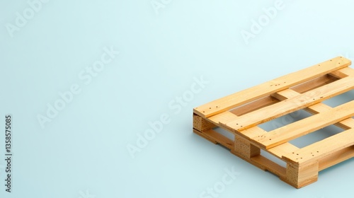 A small wooden pallet sits on a light blue background providing ample copy space for text or design elements perfect for logistics or shipping concepts.