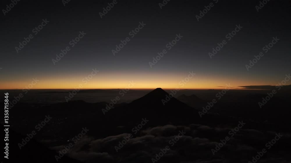 Drone flies over Acatenango Volcano to Agua Volcano at dawn before the sunrise in Guatemala Drone flies over Acatenango Volcano to Agua Volcano at dawn before the sunrise in Guatemala
