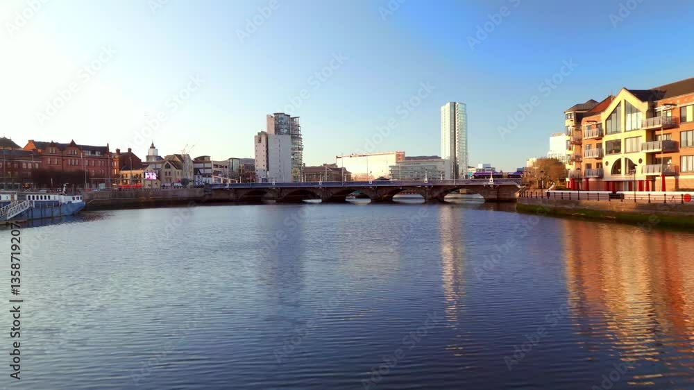 Low, forward travelling aerial shot of the River Lagan in Belfast City Centre, Northern Ireland on a sunny day. Filmed in 4K, 60fps and with Rec709 color. Low, forward travelling aerial shot of the River Lagan in Belfast City Centre, Northern Ireland on a sunny day. Filmed in 4K, 60fps and with Rec709 color.