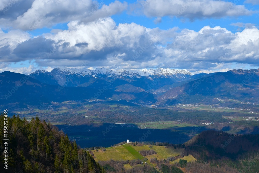 View of mountain range in Karavanke mountains and the lowlands bellow in Gorenjska, Slovenia View of mountain range in Karavanke mountains and the lowlands bellow in Gorenjska, Slovenia