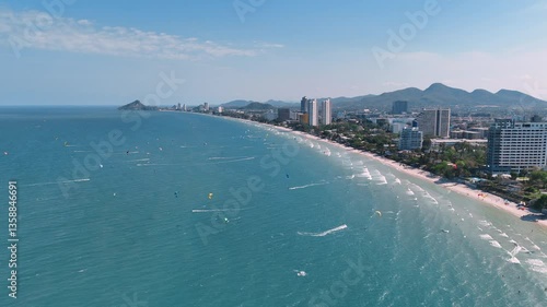 High aerial view of Kitesurfing with many riders near city beach