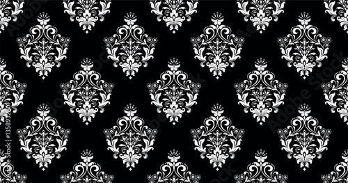 Wallpaper in the style of Baroque. White and black floral ornament. Seamless vector background. Graphic pattern for fabric, wallpaper, packaging. Ornate Damask flower illustration.