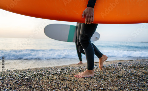 Photography Two young people, friends with surfboard going for surfing in the sea
