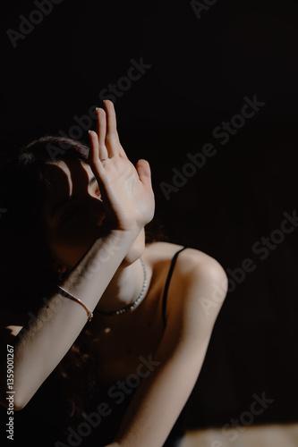 Photography the model partially covers her face with her hand, leaving only expressive lips and accessories in the frame