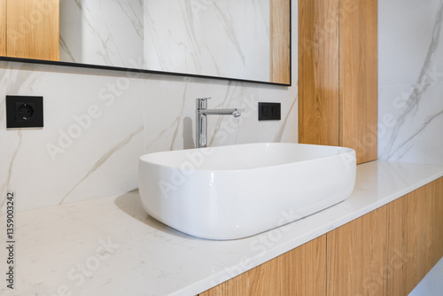 Modern bathroom design featuring a stylish sink with wooden accents