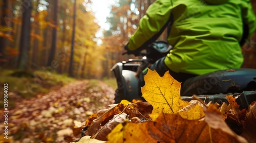 Obraz na płótnie Close-up of an ATV rider in a bright green jacket navigating through an autumn forest. The focus on the rider and the fallen leaves highlights the immersive experience of exploring nature during the w salonie