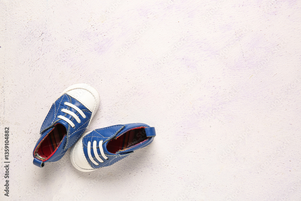 Naklejka premium Stylish baby shoes on grunge white background