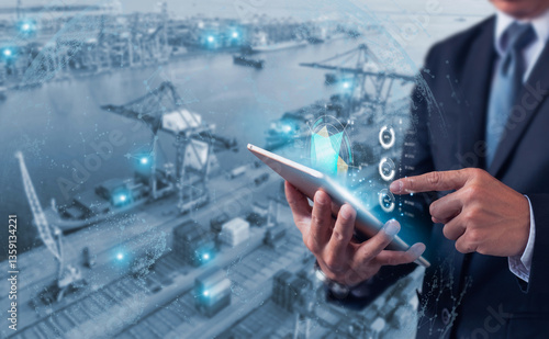 Businessman using digital tablet with futuristic interface to monitor logistics, shipping, and supply chain at a modern port.