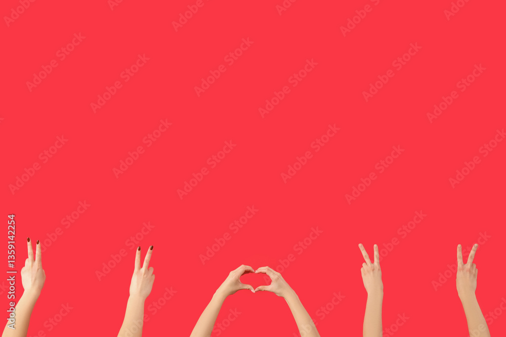 Female hands showing peace and heart gestures on red background