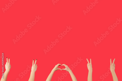 Obraz na płótnie Female hands showing peace and heart gestures on red background w salonie