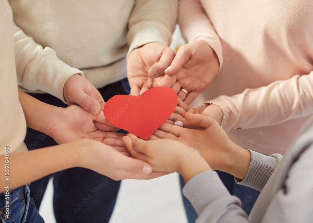 Top view close up of parents mother, father and children holding red heart in hands together as a symbol of love, care and support standing on a circle. Family health, charity or adoption concept. Top view close up of parents mother, father and children holding red heart in hands together as a symbol of love, care and support standing on a circle. Family health, charity or adoption concept.