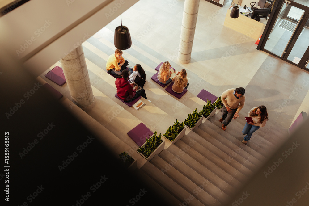 Fototapeta premium University students collaborating and walking in modern hallway