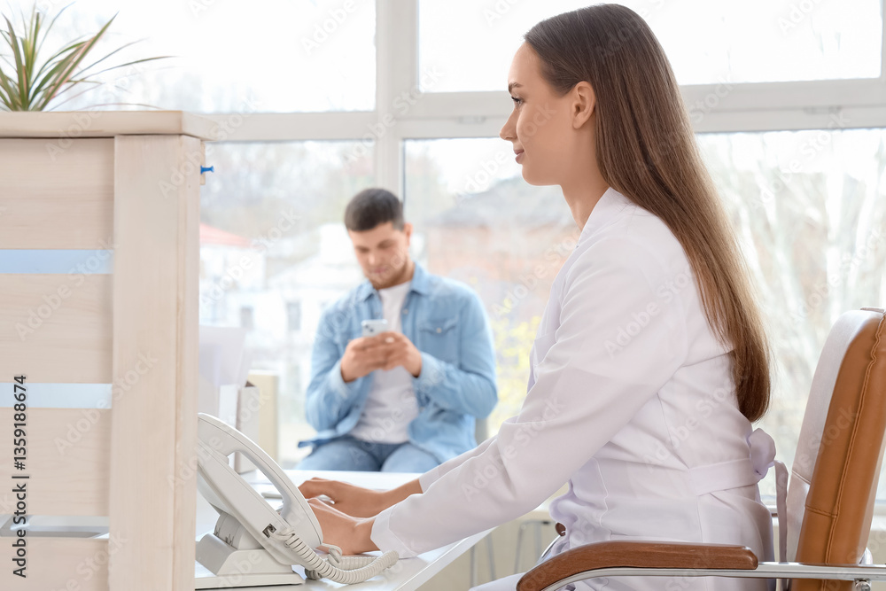 Obraz premium Female receptionist working at desk in clinic