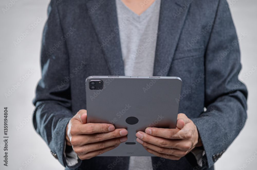 Business Professional Holding Tablet in Modern Office Environment Business Professional Holding Tablet in Modern Office Environment