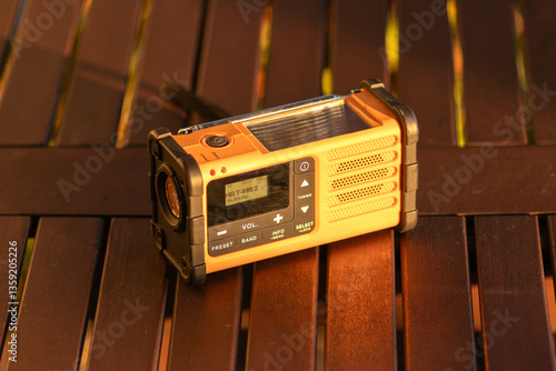 Bild auf Leinwand Portable Radio Tuner on Wooden Table During Warm Sunset Lighting Outdoors