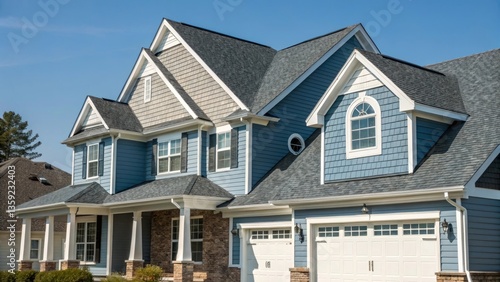 Modern suburban house with blue siding, white trim, and asphalt shingle roofing, featuring classic American architecture in a residential neighborhood.


