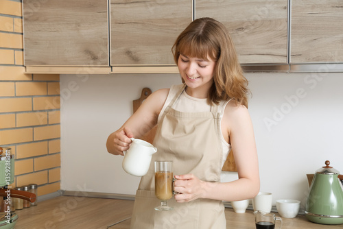 Young woman pouring milk fr...