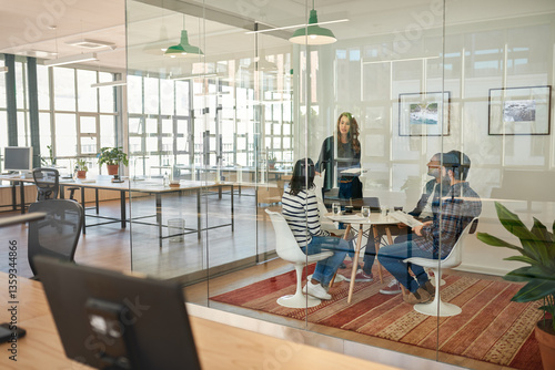 Businessman talking to colleagues sitting around a table in an office