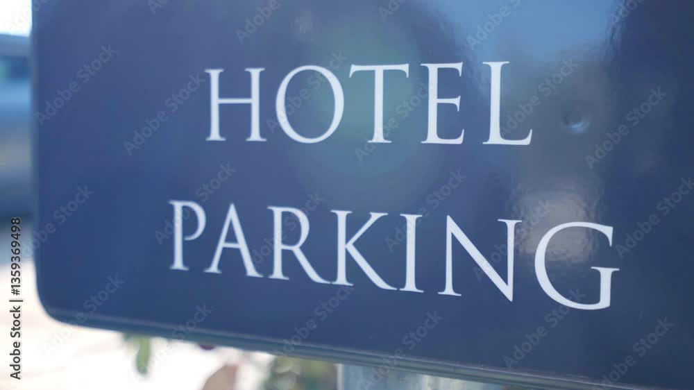 Hotel parking inscription on dark blue sign board in sunlight at the entrance of hotel, directional sign and additional information for arriving automobiles Hotel parking inscription on dark blue sign board in sunlight at the entrance of hotel, directional sign and additional information for arriving automobiles