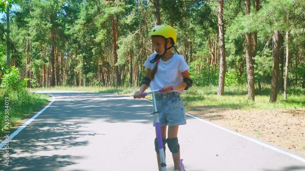 A child girl wearing a helmet riding a push scooter.