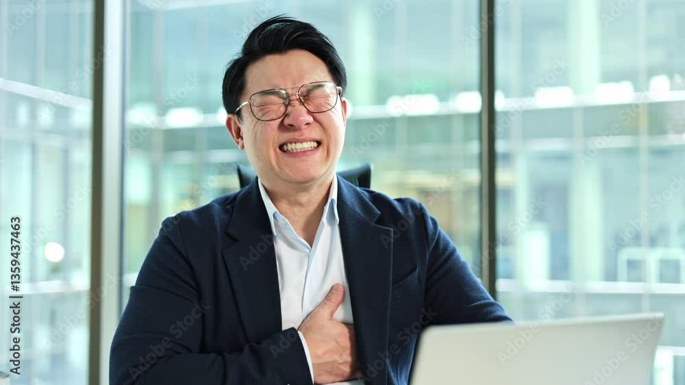Stressed Asian businessman experiencing chest pain in modern office. Exhausted male worker having heart attack, breathing heavily at workplace. Health problems at work. Stressed Asian businessman experiencing chest pain in modern office. Exhausted male worker having heart attack, breathing heavily at workplace. Health problems at work.