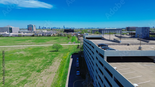 Ample vacant land in Westchase business district mixed development of office buildings and residential neighborhood, downtown Houston background, multistorey car park parking garage structure