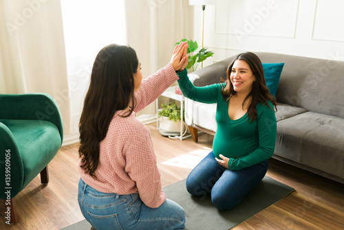 Fotografia Happy midwife and pregnant woman sharing a joyful high five during a supportive